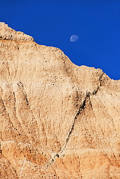 USA, South Dakota, Mountain against blue sky with moon in Badlands National Park