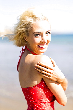 Portrait of woman wearing red swimming costume on beach