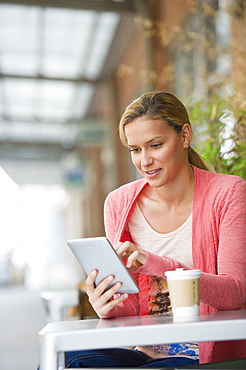 Woman using tablet in cafe