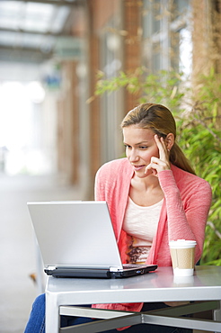 Woman using laptop in cafe