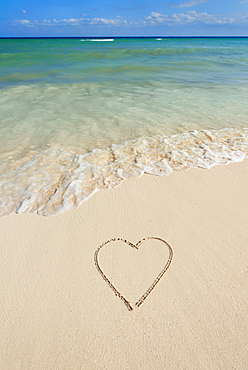 Heart drawing in sand on beach