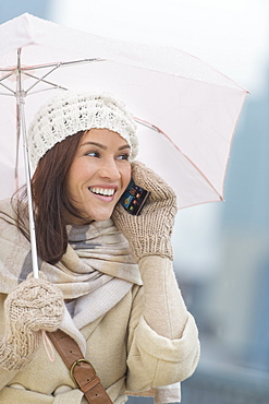 Woman with umbrella using phone