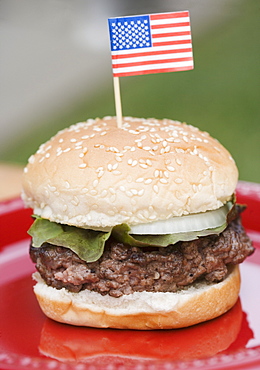 Still life of hamburger with small US flag