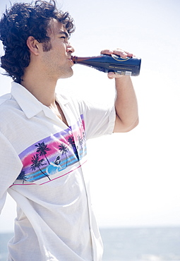 Man drinking bottle at beach