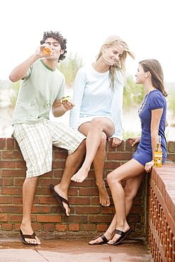 Friends leaning on brick wall