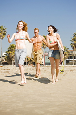 Friends carrying surfboards at beach