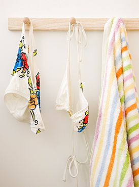 Bikini and towel hanging on rack