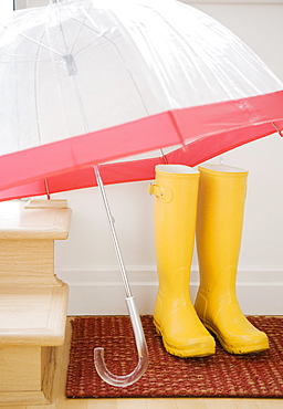 Rain boots and umbrella drying indoors