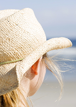 Woman in cowboy hat on beach