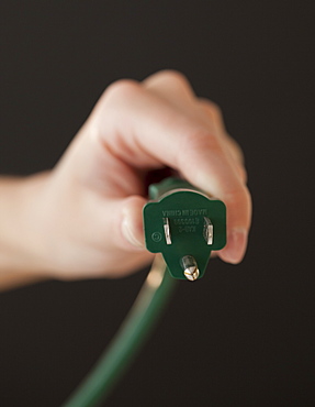 Close up of hand holding electric plug