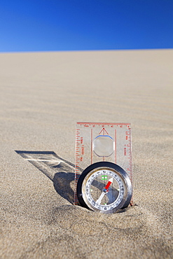 Oregon, Florence, Compass partially buried in sand