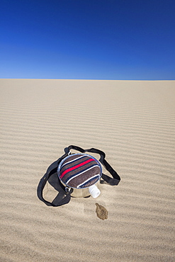 Oregon, Florence, Empty water bottle lying on sand dune