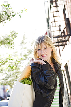 USA, New York, Williamsburg, Brooklyn, Smiling woman carrying shopping bag