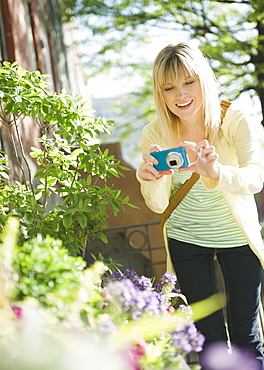 USA, Brooklyn, Williamsburg, Woman photographing flowers