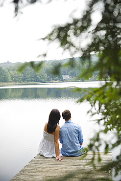 USA, New York, Putnam Valley, Roaring Brook Lake, Couple sitting on pier by lake