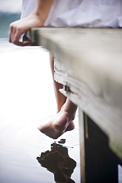 Roaring Brook Lake, Close up of legs of woman sitting on pier by lake