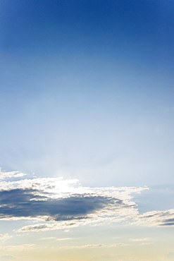 Sun covered with clouds on blue sky