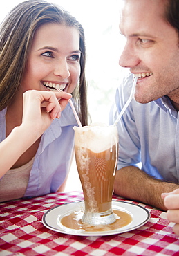 Happy young couple drinking milk shake, USA, New Jersey, Jersey City