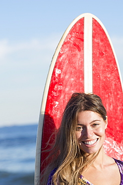 Portrait of woman with surfboard, Rockaway Beach, New York