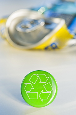 Recycling sign with crushed can, studio shot