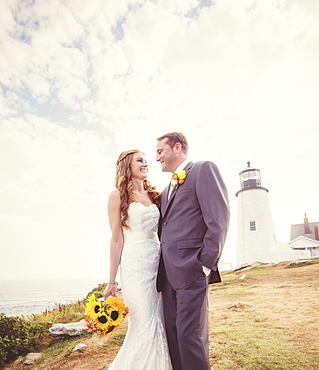 Portrait of married couple, lighthouse in background, USA, Maine, Bristol 