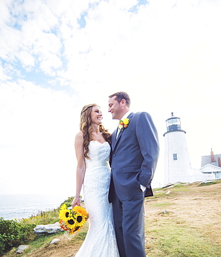 Portrait of married couple, lighthouse in background, USA, Maine, Bristol 