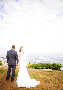 Rear view of married couple standing by sea, USA, Maine, Bristol 