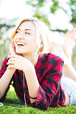 Portrait of teenage girl (16-17) lying on grass