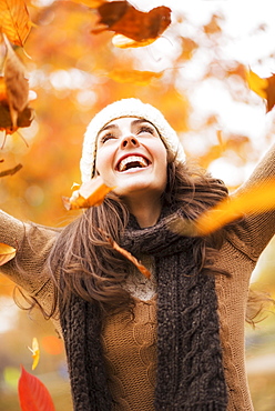 Young woman playing with leaves in Central Park, USA, New York State, New York City