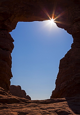 Sun flaring through Tourret Arch, USA, Utah, Arches National Park, Moab