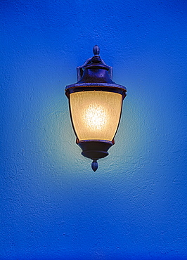 Illuminated antique street lantern floating over blue background