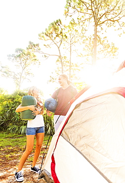 Couple standing next to tent in forest, Tequesta, Florida