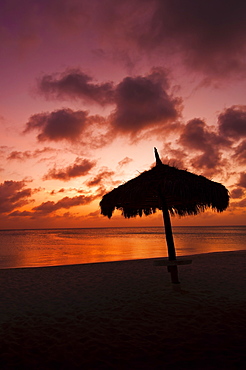 Aruba, silhouette of palapa on beach at sunset