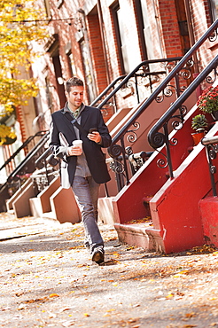 Man walking with mobile phone and coffee