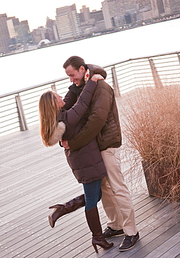 USA, New York, Long Island City, Young couple embracing on boardwalk