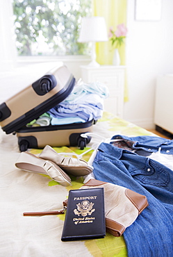 Suitcase and passport on bed during packing