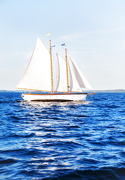 Small yacht sailing on blue sea