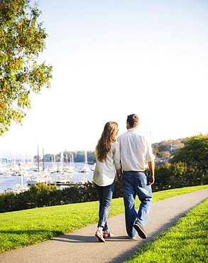 Couple walking with harbor in background, Camden, Maine