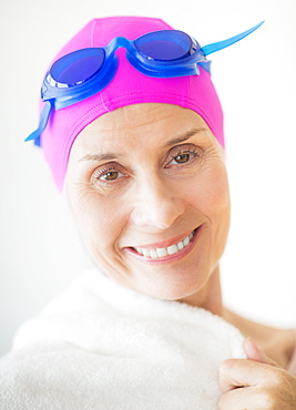 Portrait of smiling woman in swimming cap and goggles