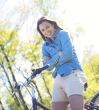 Portrait of mid adult woman with bicycle, Central Park, New York City