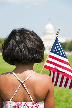 USA, Washington DC, girl (10-11) with US flag in front of Capitol Building