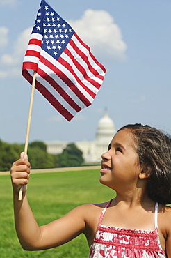 USA, Washington DC, girl (10-11) with US flag in front of Capitol Building