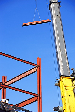 Crane holding steel girder