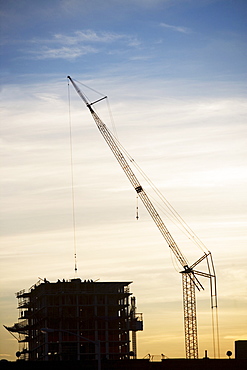 Crane and urban construction site at dusk
