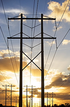 Electrical poles and wires at sunset