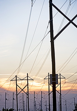 Electrical poles and wires at sunset