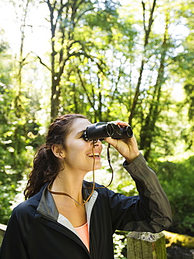 Portrait of woman looking at view with binoculars, USA, Oregon, Portland