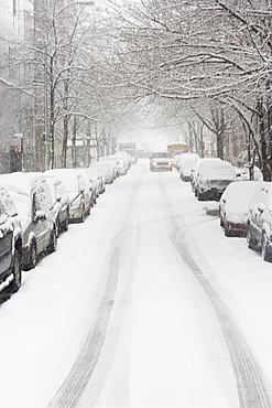 USA, New York City, snowy street with rows of parked cars