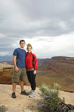 Couple standing at edge of cliff