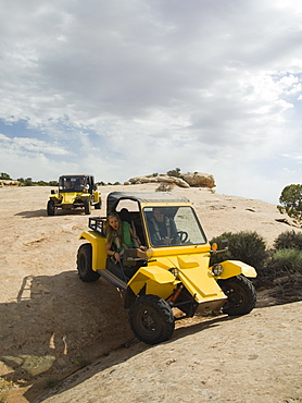 People in off-road vehicles on rock formation